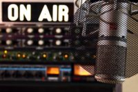 image of microphone with the words 'on air' in the background for radio advertising as part of your web design and marketing package